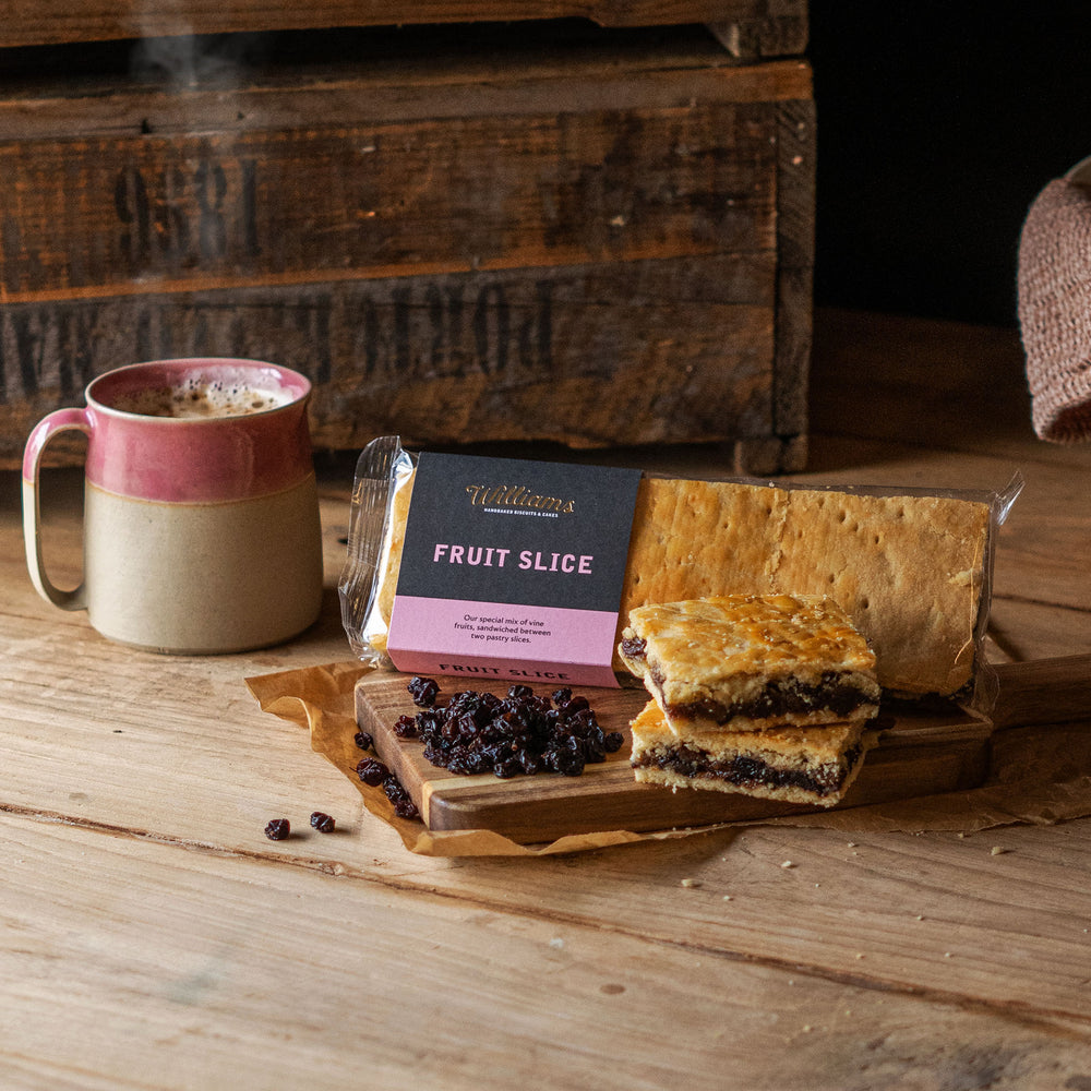 Fruit Slice, with two loose slices in the foreground, next to a pile of currants and a cup of coffee.